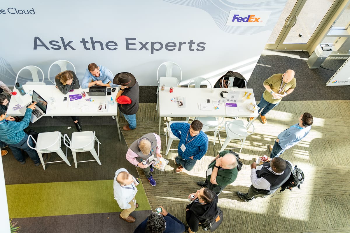 Overhead view of attendees speaking with experts at a branded FedEx event activation