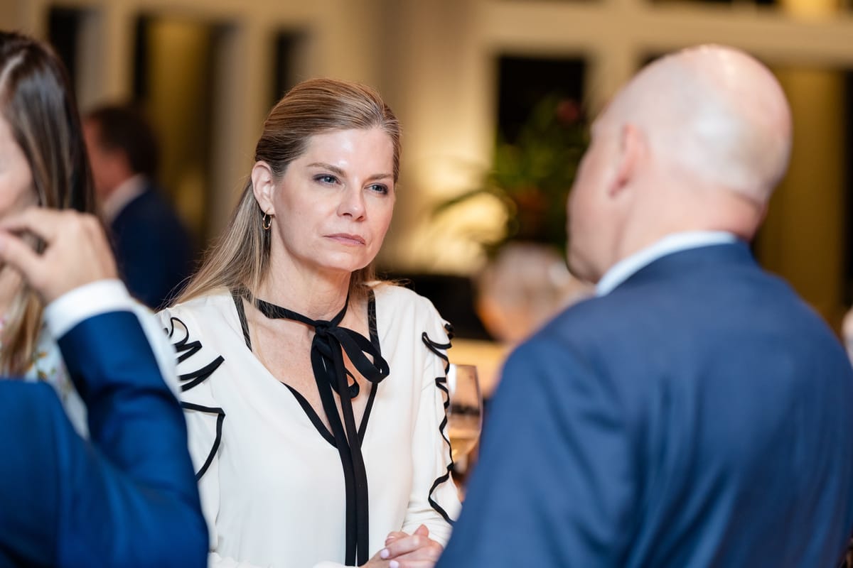 Two guests in a focused conversation during the Naples Cardiovascular Summit evening reception