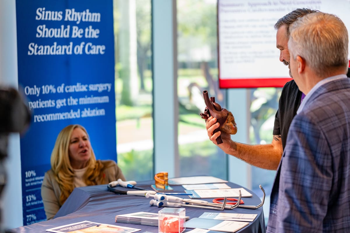 Exhibitor demonstrating an anatomical heart model to attendees at the Naples Cardiovascular Summit